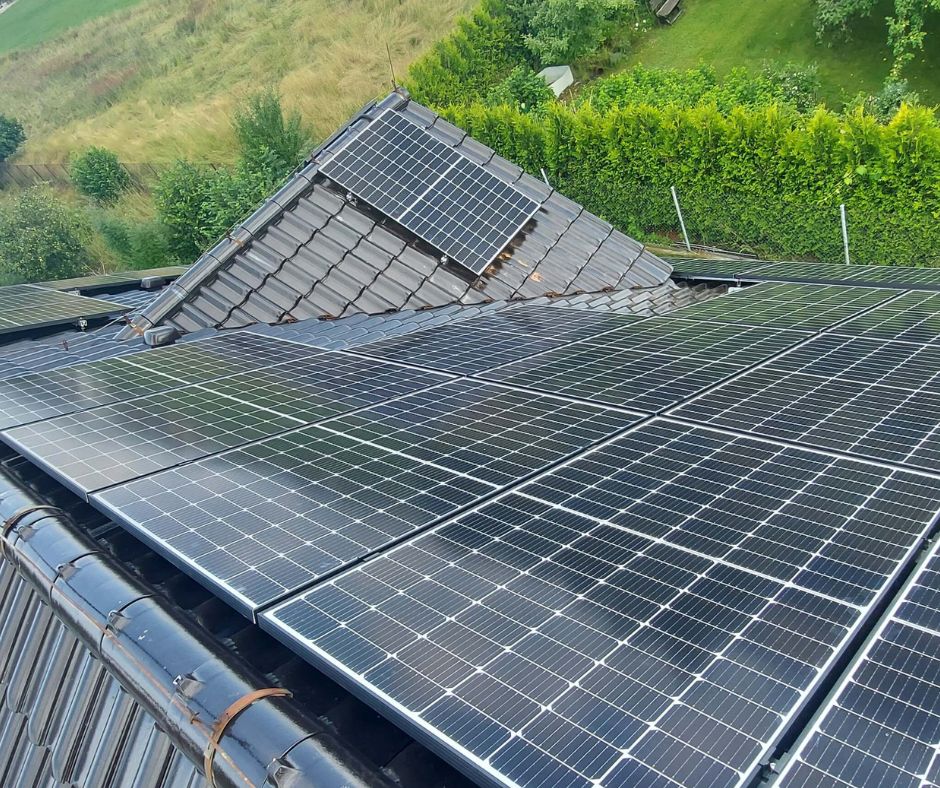 Widok z góry na panele fotowoltaiczne JA Solar ułożone na dachu domu jednorodzinnego