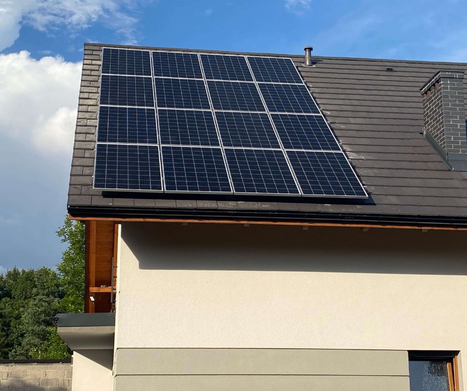 Zbliżenie na moduły fotowoltaiczne JA Solar ułożone na dachu domu jednorodzinnego